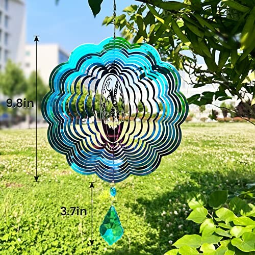 Blue metal wind spinner hanging in a garden.